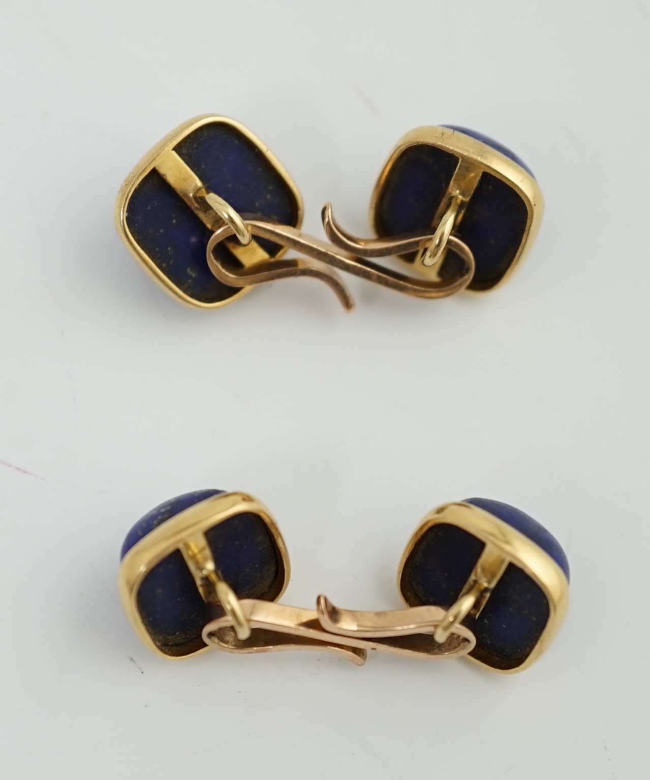 A pair of gold mounted cabochon lapis lazuli set cufflinks